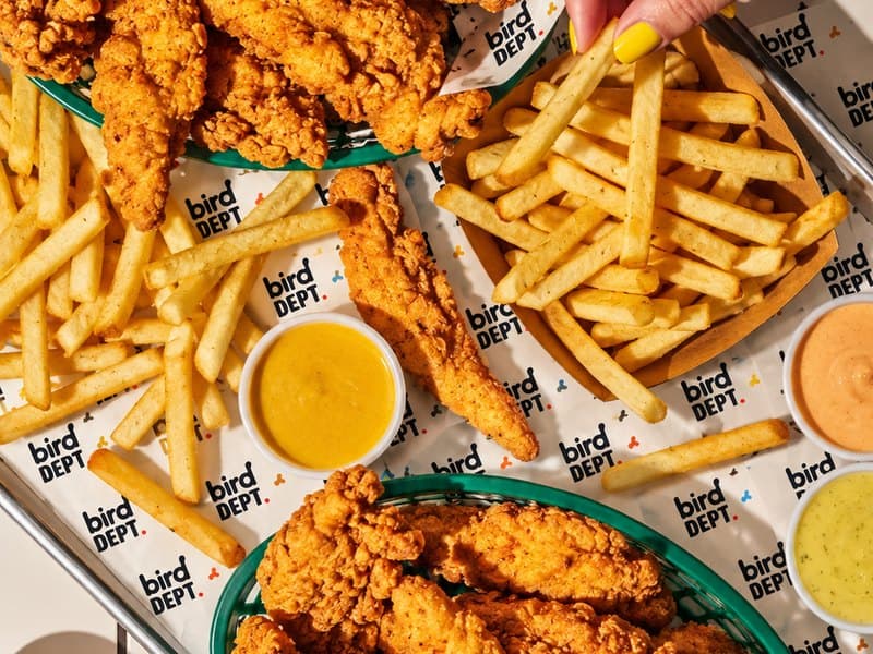 Chicken tenders in branded baskets with fries and four dips